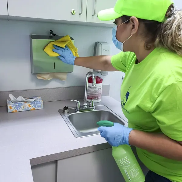 Staff member using eco-friendly cleaning methods in a daycare setting
