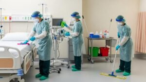 Healthcare professionals cleaning a medical facility with PPE, emphasizing safety and hygiene